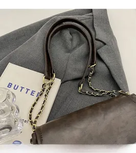 Detail of dark brown leather strap with metal chain on a vintage shoulder bag