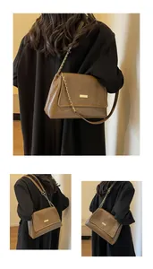 Detail shots of brown leather chain crossbody bag with golden rectangular metal clasp