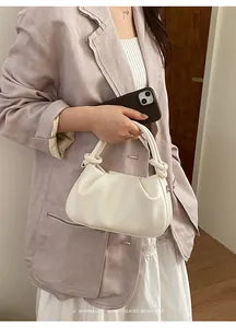 Detailansicht der cremeweißen Plissee-Tasche mit Knotengriff und weicher PU-Leder-Struktur
