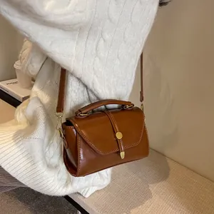 Classic retro brown leather crossbody bag with golden round buckle and top handle