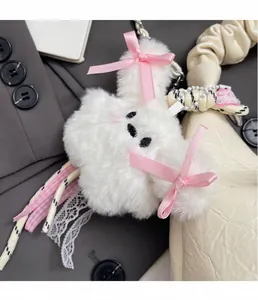 Witte pluche hanger met roze linten en kant aan een crème getextureerde handtas