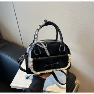 Detail of black glossy bowling bag featuring white lace trim and ribbon-wrapped handle
