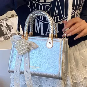 Zilveren kleine crossbodytas met modetekst en hartvormige kanten parelhanger