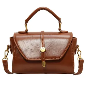 Brown vintage leather top-handle bag with gold hardware and detachable shoulder strap