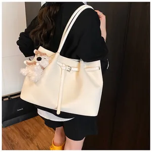 Close-up of beige lizard texture tote bag with plush puppy pendant for daily commuting