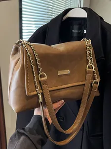 Brown faux leather tote bag with gold chain strap and metallic flap decoration