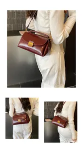 Détail du sac à main en cuir bordeaux avec fermoir en métal doré et texture brillante