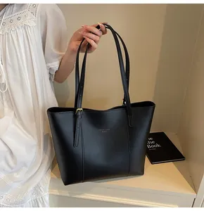 Detail of black tote bag with adjustable handles, golden buckles and fashion text logo