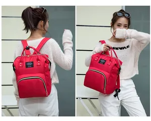 Detailansicht des roten Multifunktions-Wickelrucksacks mit LIVING TRAVELING SHARE Label