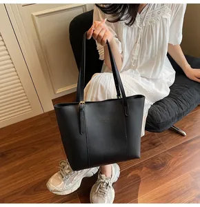 Detail of high-quality black tote bag with gold hardware and Fashion Trend text logo