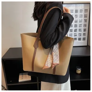 Detail of khaki tote bag with matte PU leather and decorative geometric pattern scarf