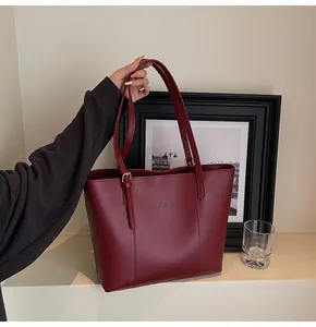 Close-up of wine red tote bag with adjustable metal buckle and fashion trend text
