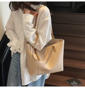 Beige tote bag with vertical stitching shown in a stylish street lifestyle setting