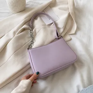 Detalle del bolso de hombro lila con cadena de metal plateado y correa de piel sintética