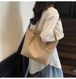 Detail view of the beige tote bag with Fashion Living text and brown shoulder straps