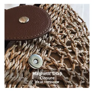 Detail einer handgewebten Strohtasche mit brauner Lederklappe und Magnetverschluss
