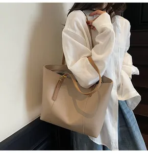 Close-up of the beige tote bag featuring Fashion Trend lettering and slim brown straps