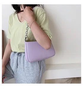 Bolso de hombro lila con cadena plateada mostrado en una modelo con atuendo informal