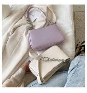 Vista superior de bolsos baguette morados y beige con detalles de cadena plateada