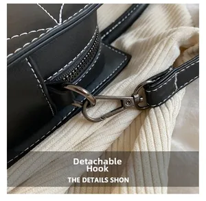 Detail of the detachable gunmetal swivel hook on a black quilted leather tote bag