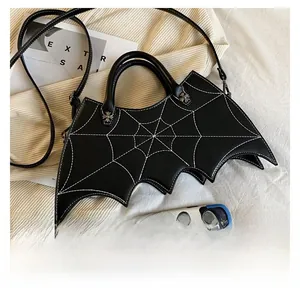Detail of bat-shaped black PU bag with spiderweb stitching and cross hardware for size scale