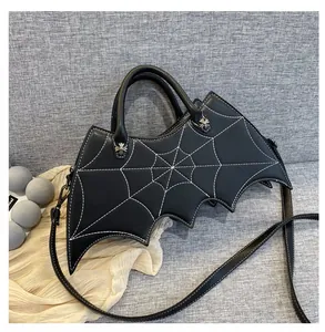 Close-up of bat-shaped gothic bag with spider web stitching and silver cross hardware
