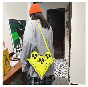 Détail d'un sac bandoulière jaune en forme de fantôme porté par un mannequin dans un décor cosy