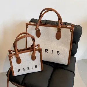 Detail showing two sizes of canvas tote bags with leather trim and Paris lettering