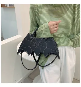 Macro detail of bat-shaped PU bag with spider web stitching and gothic cross metal decor