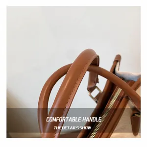 Detail of round leather handle on canvas tote bag with contrast stitching craftsmanship