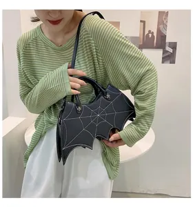Detail of bat-shaped black PU leather bag with spiderweb stitching and star rivets