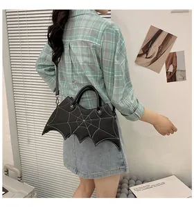 Close-up of black bat-shaped PU handbag featuring white spider web stitching detail