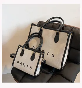 Detail view of the Paris canvas tote bag showing the black leather trim and metal hardware