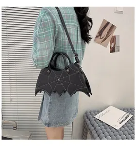 Gothic bat-shaped handbag with white spiderweb stitching and metallic spider details