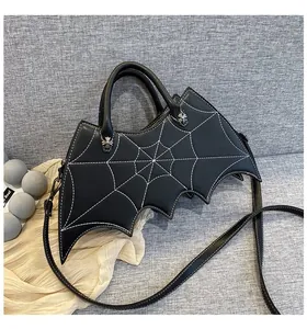 Detail of gothic bat-shaped bag featuring white spider web stitching and metal buckle