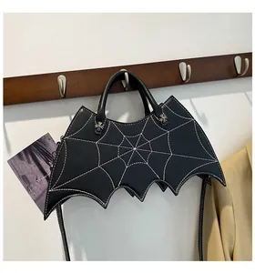 Close-up of black bat-shaped Halloween bag with white spider web stitching and metal rivets