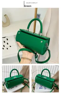 Close-up of green cylinder handbag with silver hardware and adjustable shoulder strap