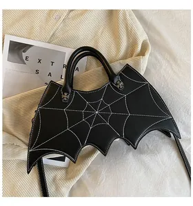 Detail of bat-shaped bag featuring white spiderweb stitching and silver cross rivets