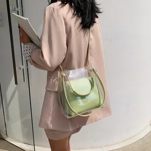 Transparent PVC tote with green inner leather pouch and adjustable gold strap