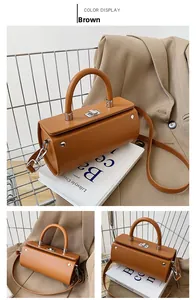 Detail view of a vintage brown cylindrical bag with silver hardware and smooth leather finish