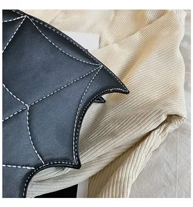 Close-up of black bat-shaped PU leather bag with contrast white stitching details