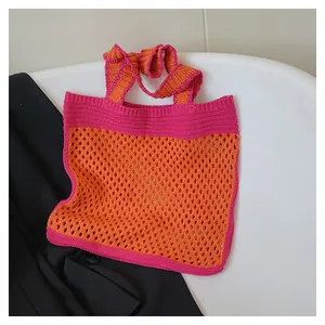 Close-up of orange and pink knit tote bag with hollow mesh and dense stitch details