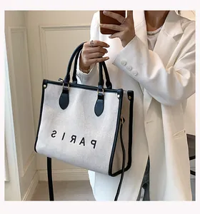 Close-up of white canvas tote bag with black trim and PARIS print for daily fashion