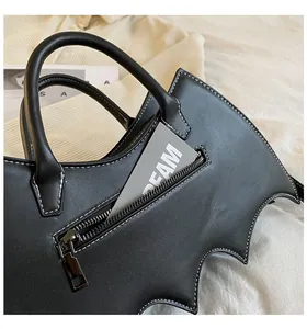 Detail of bat wing handbag with white contrast stitching and matte black leather finish