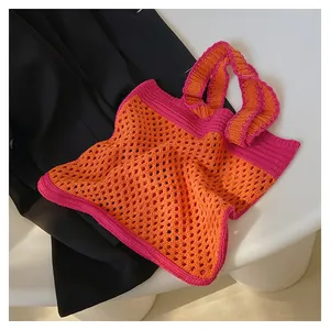 Macro detail of hand-woven crochet tote bag showing orange mesh and purple handles