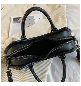 Top view of bat handbag opening with white contrast stitching and adjustable strap