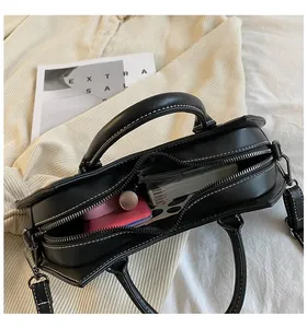 Interior view of black bat tote bag showing capacity for wallet and lipstick with zipper