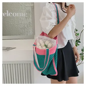 Detailed close-up of a handmade knit tote bag in green and pink with mesh texture