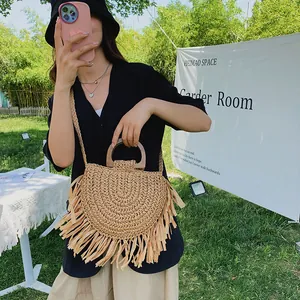 Chic woven bohemian straw beach bag with wooden handles and long decorative tassels