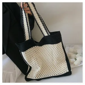 Detailed close-up of handmade knit tote bag with black and beige crochet mesh pattern